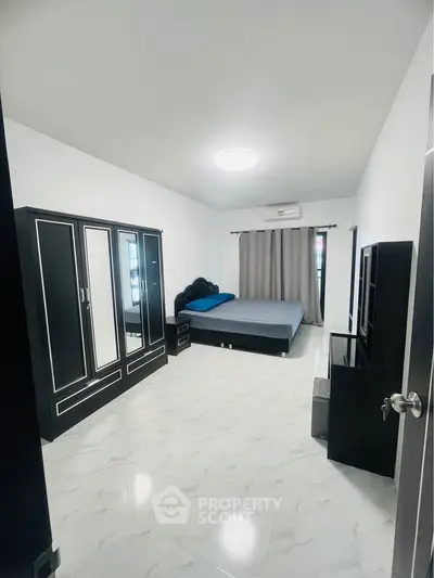 Spacious bedroom with modern furniture and sleek design, perfect for comfort and style.