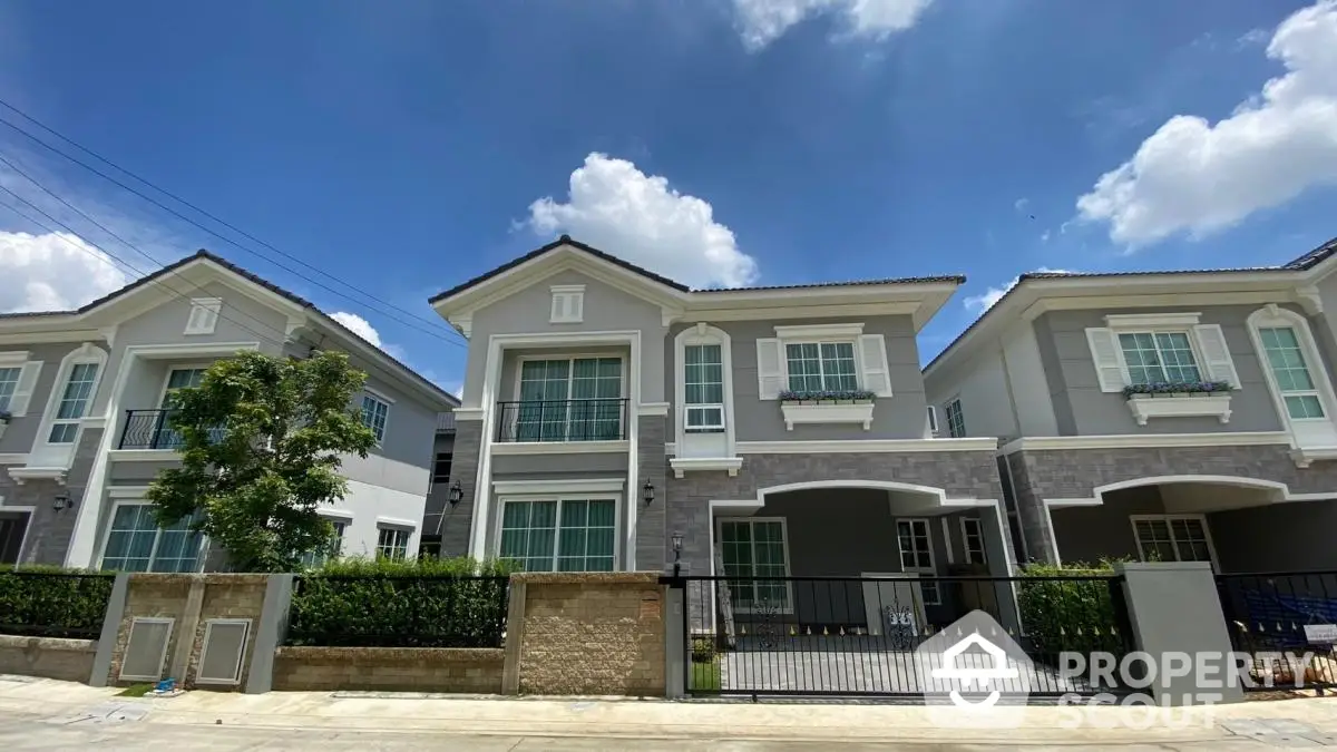 Modern townhouse exterior with blue sky and lush greenery, perfect for family living.