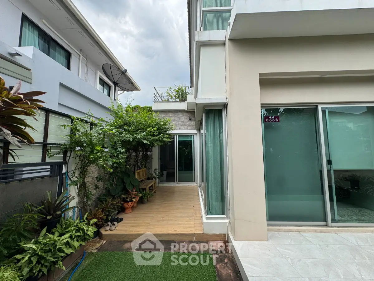 Modern townhouse exterior with lush garden and wooden deck