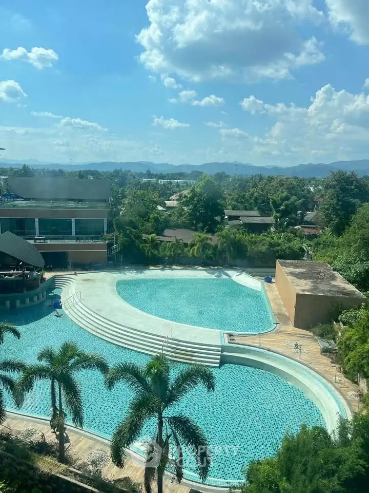 Stunning pool view with lush greenery and clear blue skies, perfect for relaxation and leisure.