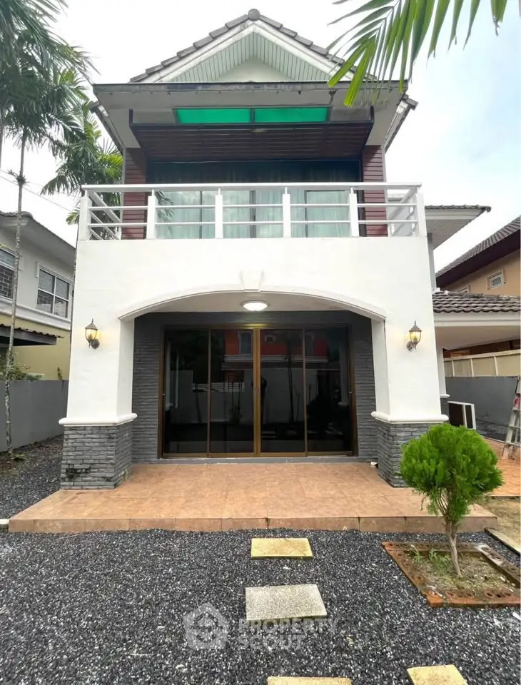 Charming two-story house with balcony and modern exterior design, perfect for family living.