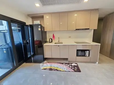 Modern kitchen with sleek cabinetry and large fridge in a bright apartment.