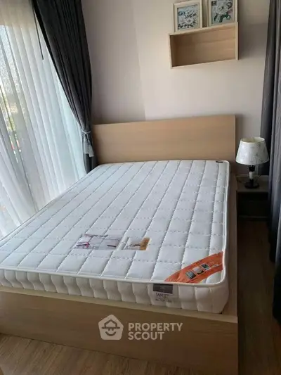 Cozy bedroom with natural light, featuring a modern bed and stylish decor, perfect for relaxation.