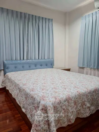 Cozy bedroom with elegant curtains and a stylish bedspread, perfect for a restful retreat.