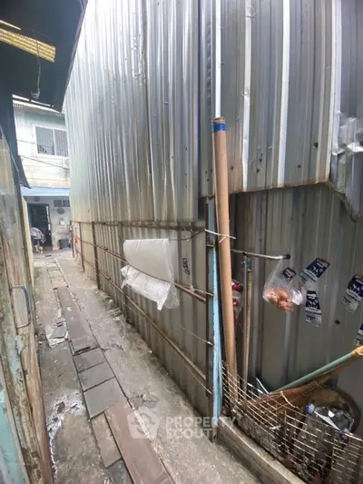 Narrow alleyway with corrugated metal walls and rustic charm