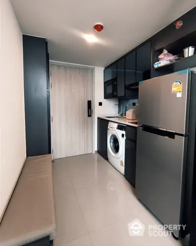 Modern compact kitchen with washing machine and stainless steel fridge