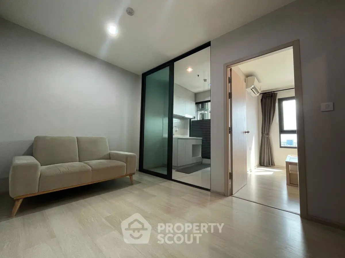 Modern apartment interior with open layout, featuring a cozy living room and sleek kitchen design.