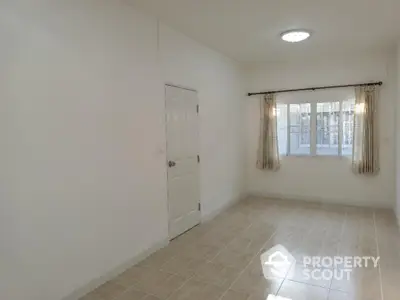 Bright and spacious tiled living room with large windows and neutral color palette, perfect for personal customization.