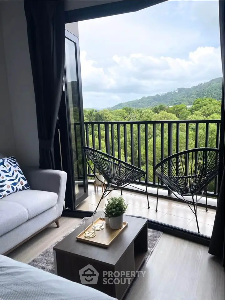 Chic living room with open balcony offering stunning green views, perfect for relaxation.