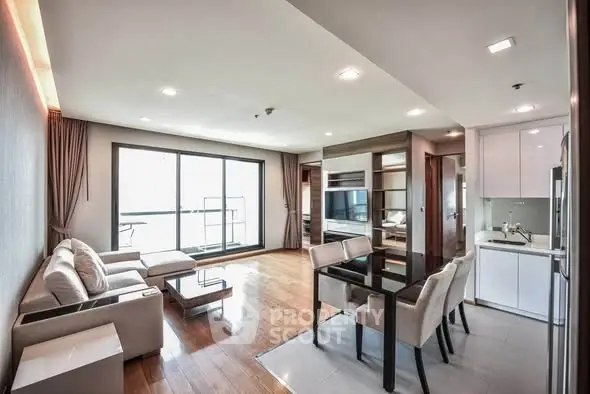 Spacious modern living room with open kitchen and large windows in luxury apartment.