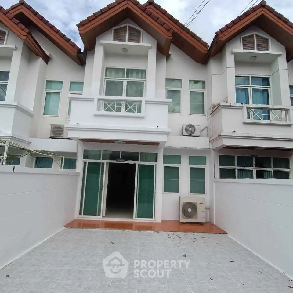 Charming townhouse with modern facade and spacious driveway, perfect for family living.