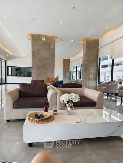 Luxurious modern living room with elegant furniture and marble accents in a spacious open layout.