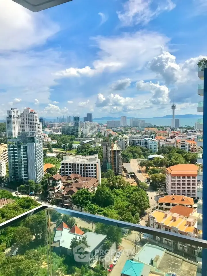Stunning cityscape view from a high-rise balcony showcasing urban skyline and lush greenery.