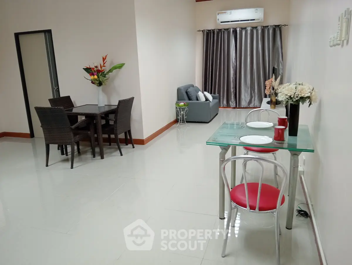 Spacious open-plan living and dining area with modern furnishings and air conditioning.