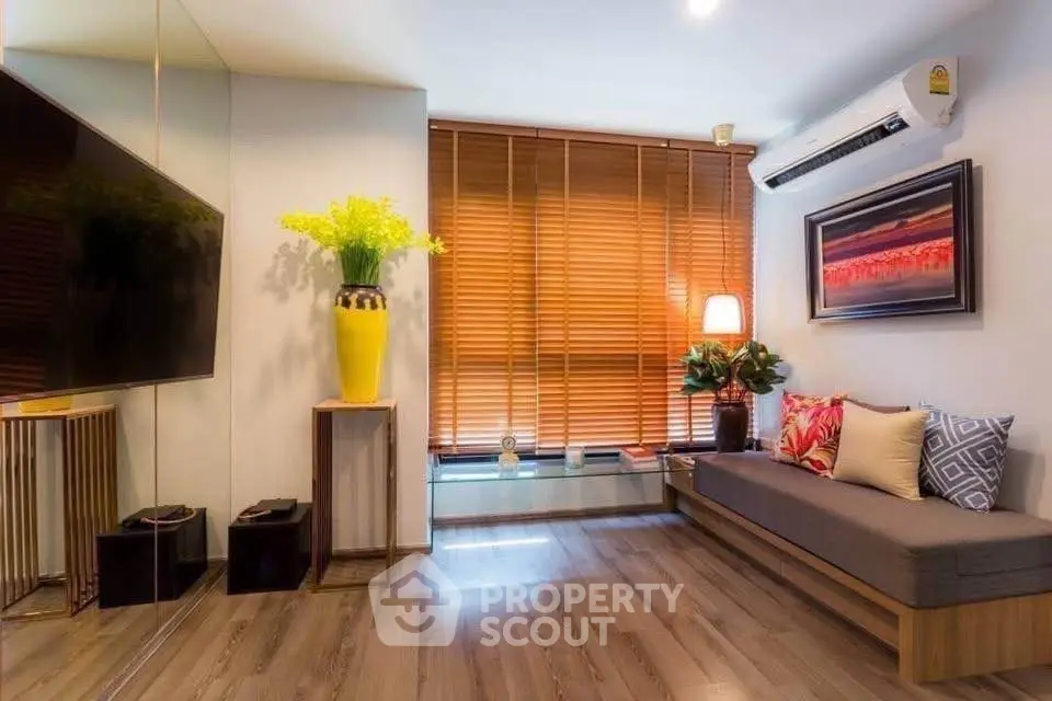 Stylish living room with modern decor, large TV, and cozy seating area.