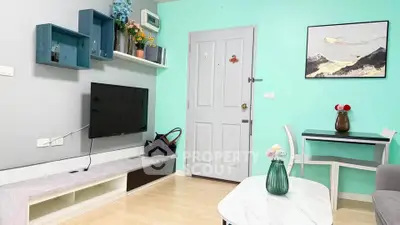 Charming living room with modern decor and pastel walls, featuring a wall-mounted TV and stylish furniture.