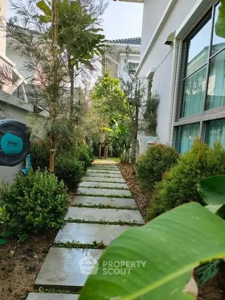 Charming garden pathway with lush greenery and modern exterior design.