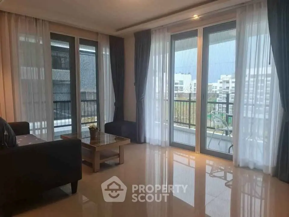 Spacious living room with large windows and balcony view in modern apartment.