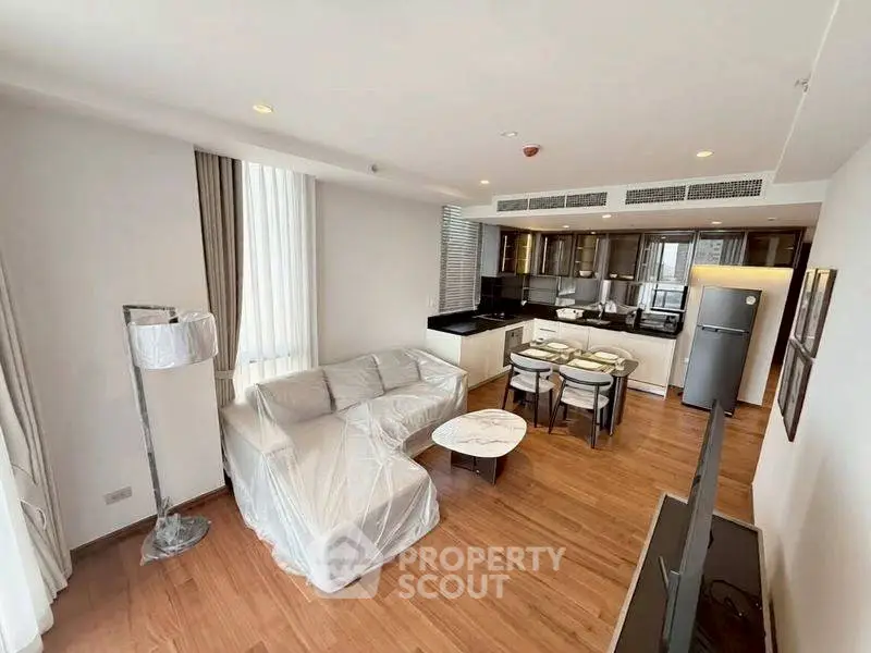 Spacious modern living room with open kitchen and elegant furnishings in a luxury apartment.