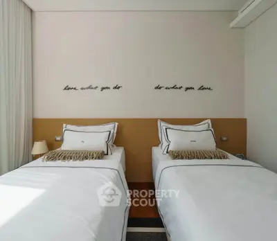 Elegant twin bedroom with stylish decor and motivational wall art, perfect for modern living.
