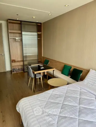 Modern bedroom with stylish decor and cozy seating area in a luxury apartment.