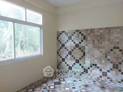 Bright room with large window and colorful mosaic tile floor and wall