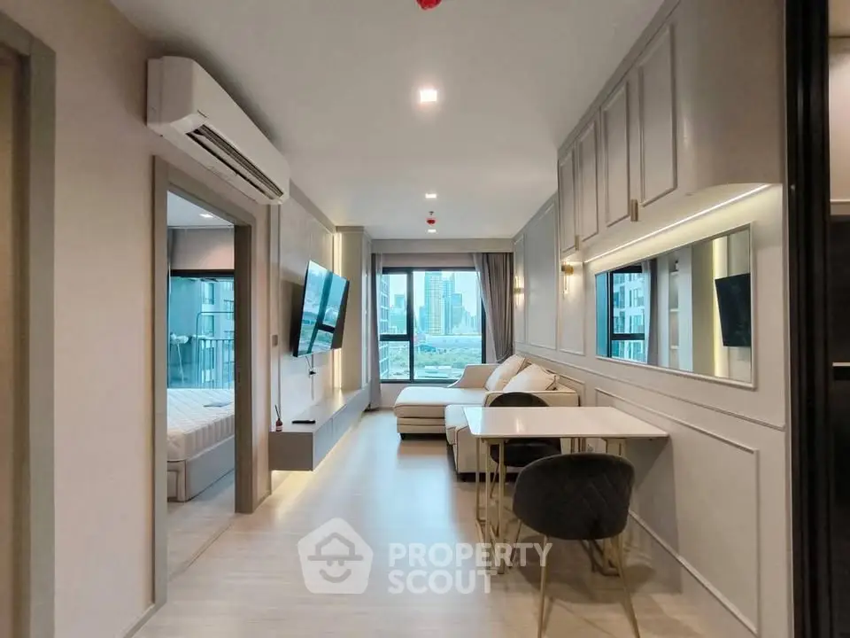 Modern apartment interior with open living and dining area, featuring sleek design and city view.