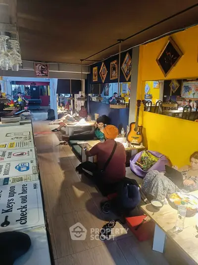 Cozy lounge area with vibrant decor and guitar, perfect for relaxation and socializing.