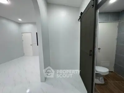 Modern bathroom with sliding barn door and sleek white tiles