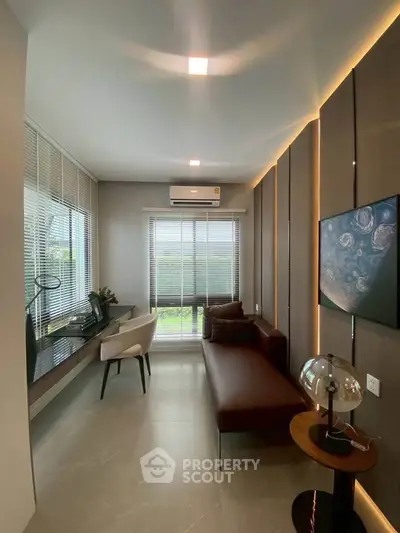Modern living room with sleek furniture and large window offering natural light.