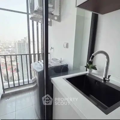 Modern balcony with city view, featuring a sleek black sink and washing machine, perfect for urban living.