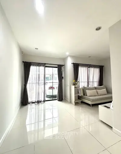 Bright and spacious living room with modern decor and large windows