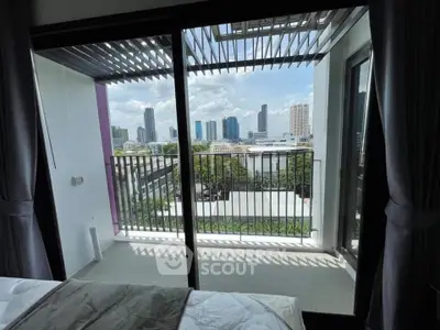 Modern bedroom with balcony offering stunning city skyline view