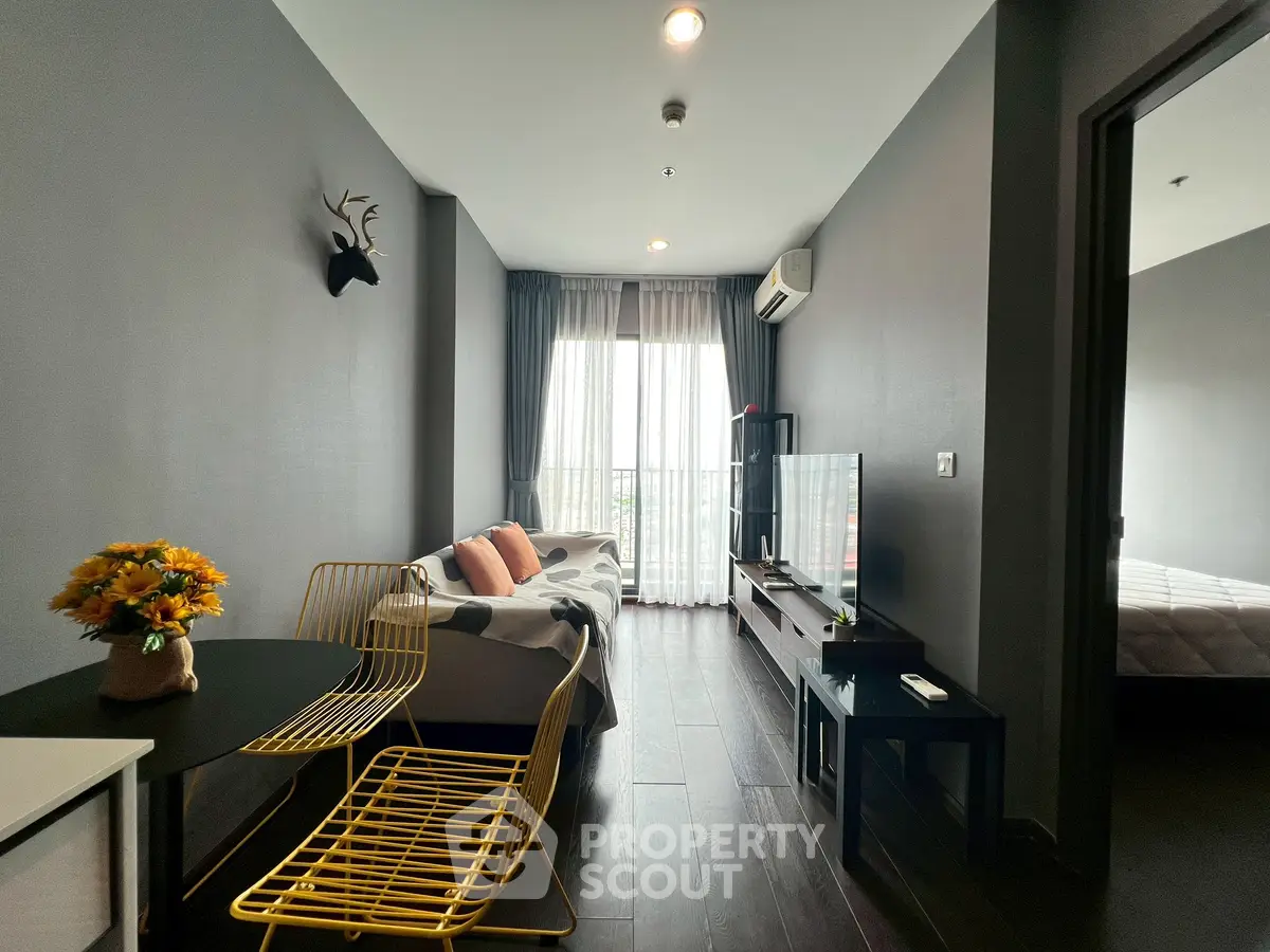 Modern living room with stylish decor and natural light, featuring cozy seating and elegant furnishings.