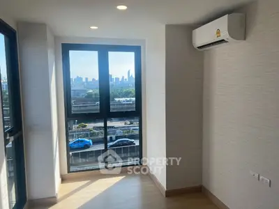 Bright room with large windows offering a stunning city view and modern air conditioning.