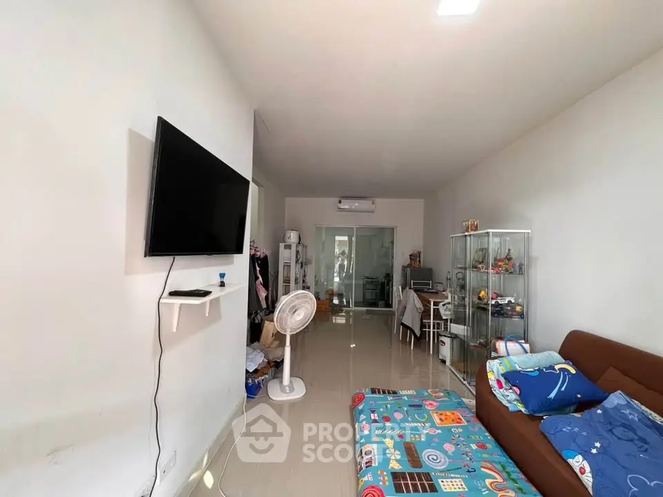 Spacious living room with modern decor and wall-mounted TV, perfect for family gatherings.