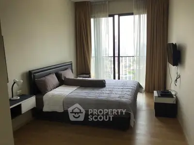 Modern bedroom with large window and stylish decor in a high-rise apartment.