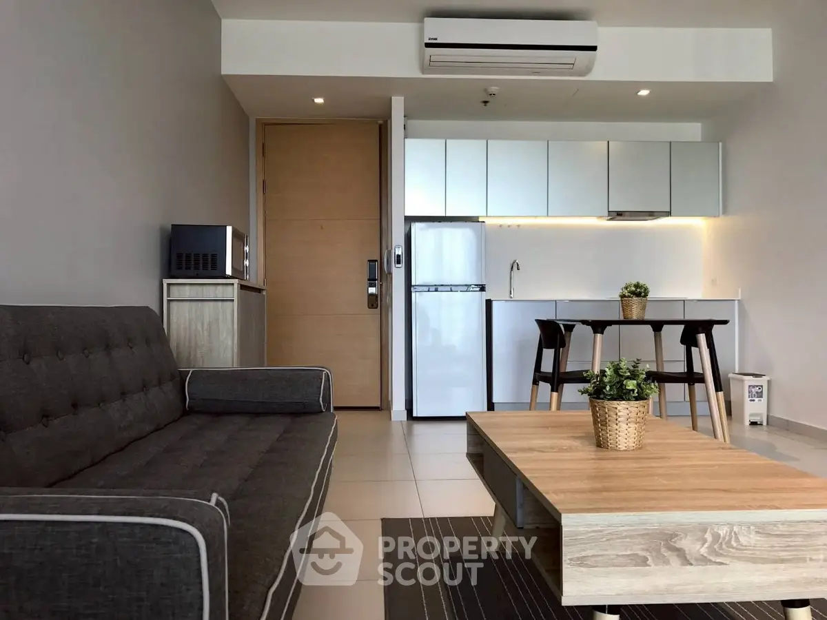 Modern living room with sleek kitchen, stylish furniture, and contemporary design.