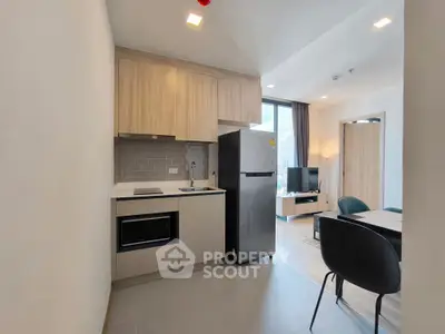 Modern kitchen with sleek appliances and open layout leading to cozy living area.