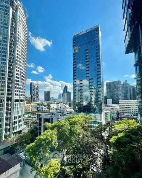 Stunning cityscape view from high-rise building with lush greenery and modern architecture.