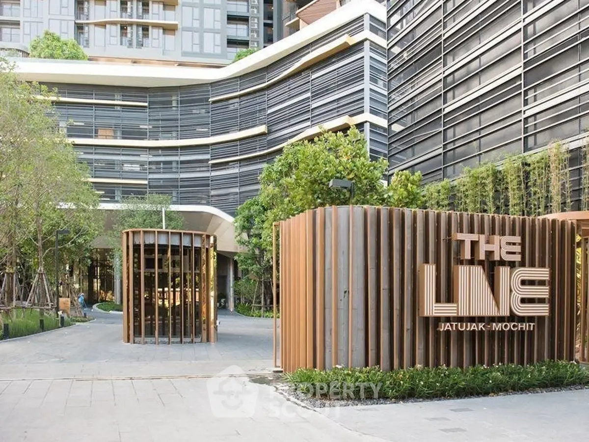 Modern urban residential building with stylish entrance and lush greenery at The Line Jatujak-Mochit.