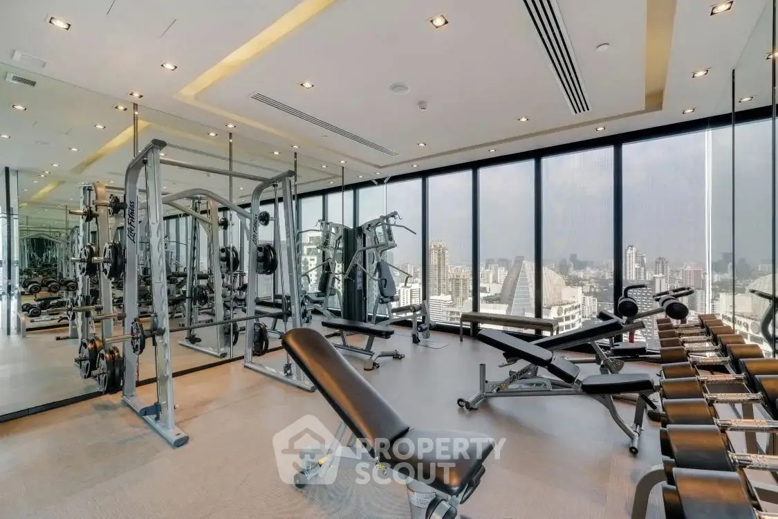 Luxurious gym with panoramic windows and modern equipment in high-end real estate property.