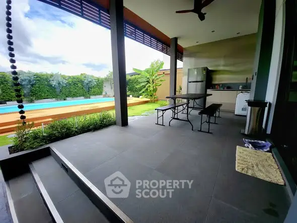 Modern outdoor patio with pool view and sleek kitchen area.