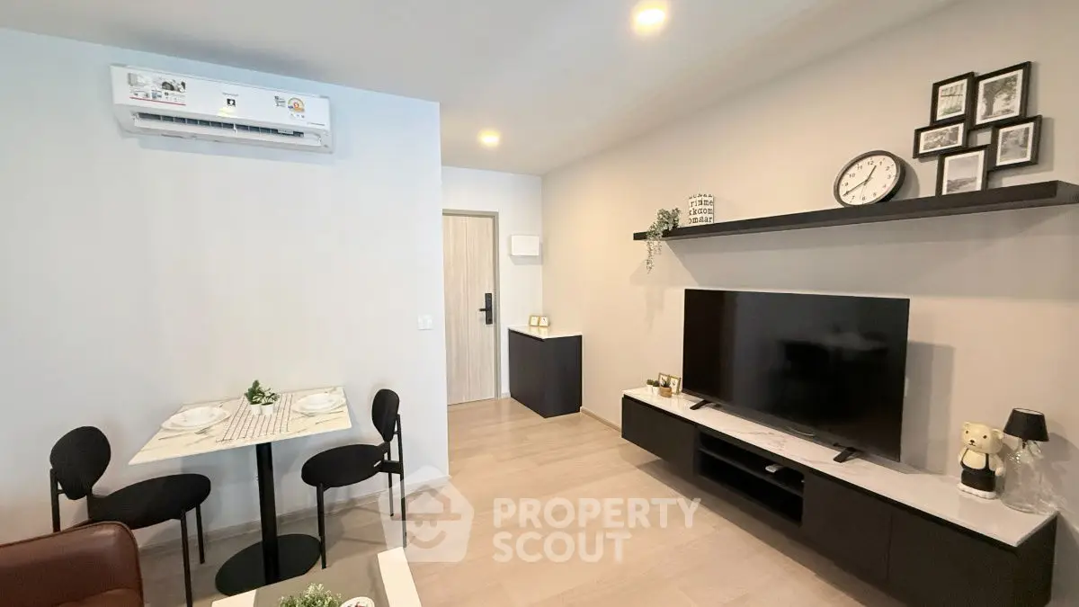 Modern living room with sleek furniture and wall-mounted TV in a cozy apartment.