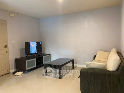 Cozy living room with modern furniture and TV setup, perfect for relaxation.