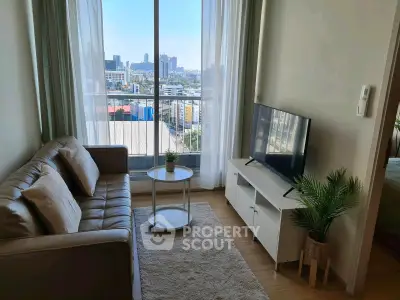 Modern living room with city view, cozy sofa, and sleek TV setup in a high-rise apartment.