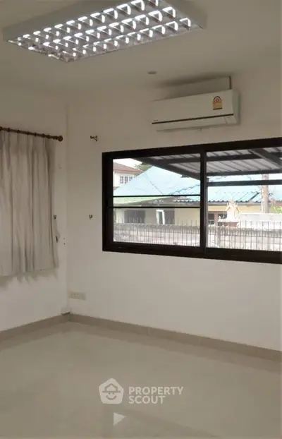 Bright empty room with air conditioning and large window view