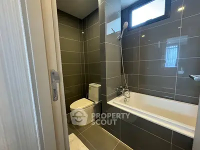 Modern bathroom with sleek gray tiles and a bathtub