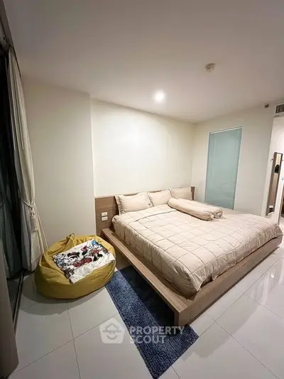 Modern bedroom with cozy bed and bean bag in stylish apartment