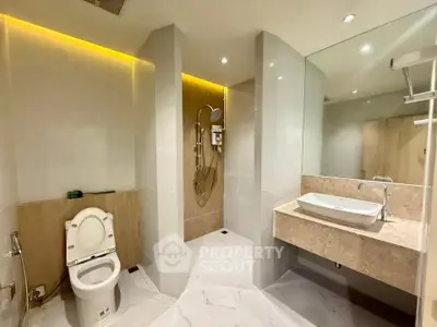 Modern bathroom with sleek design, featuring a spacious shower and elegant vanity.